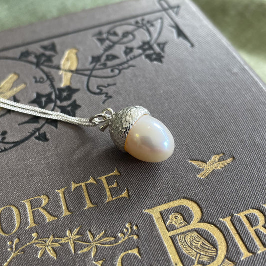 Large silver acorn charm on necklace with a pearl. 