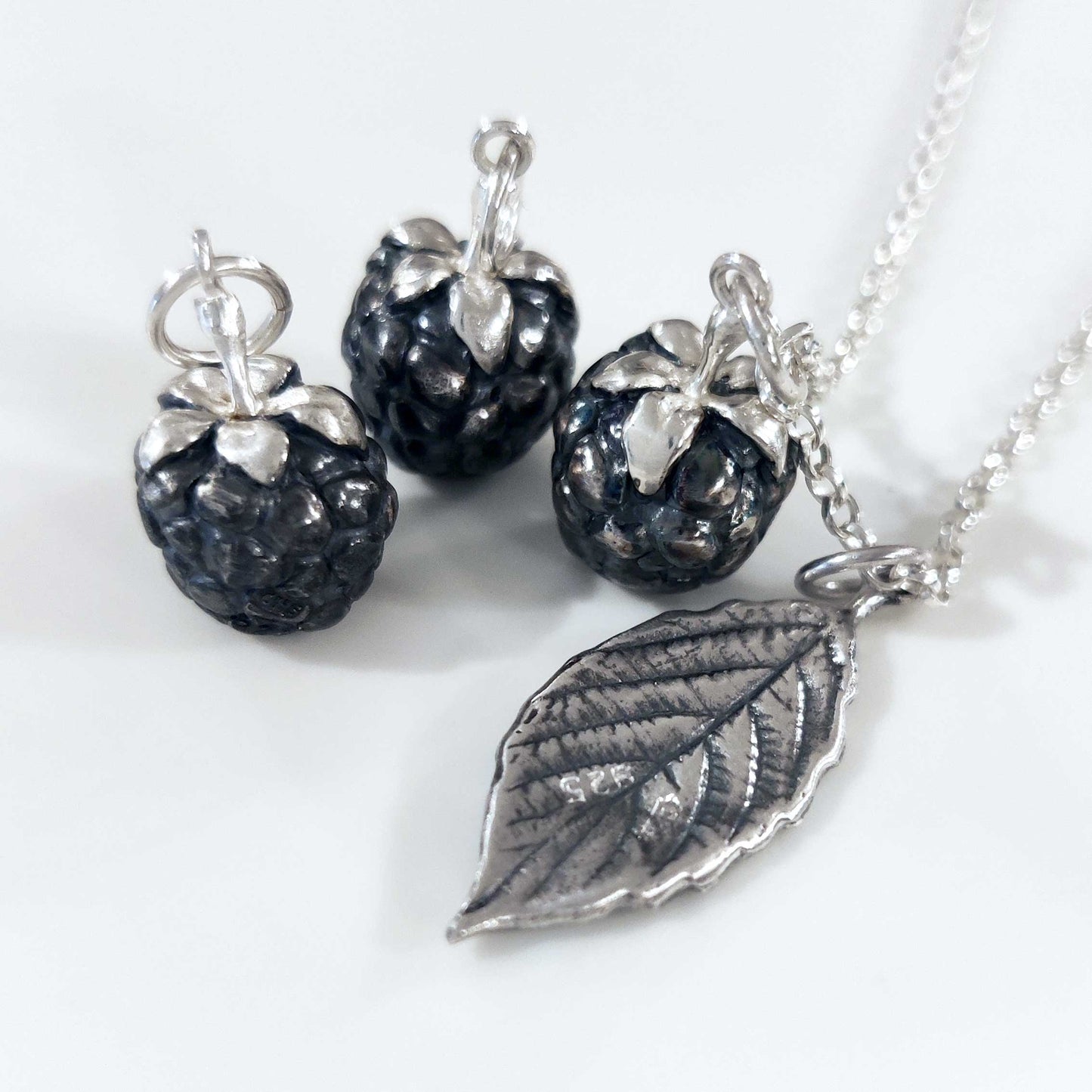 Three blackberries and leaf