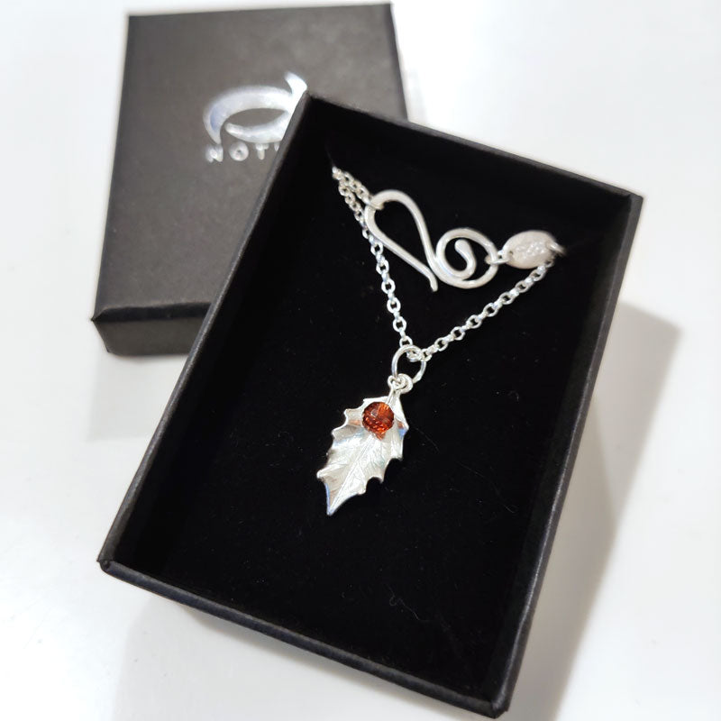 Boxed tiny silver holly leaf with Mozambique garnets